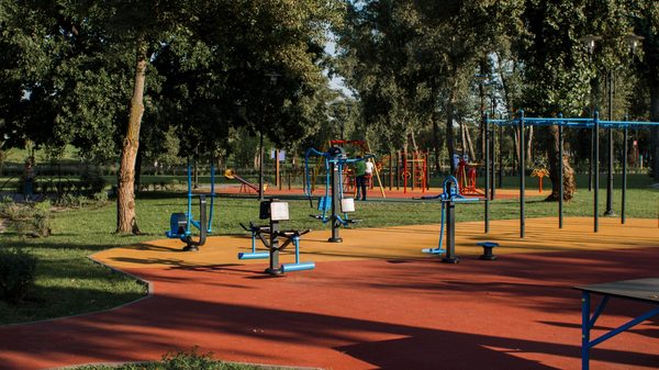 An outdoor gym and play area on a rubber surface