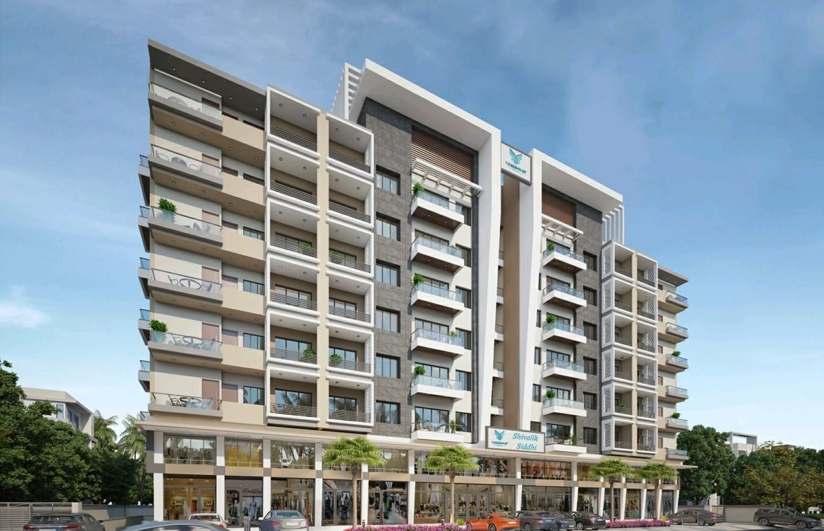 Shivalik Siddhi seen from the road: a residential block in beige, white and grey stone cladding with balconies on every floor, above a glazed row of shops, architect's render
